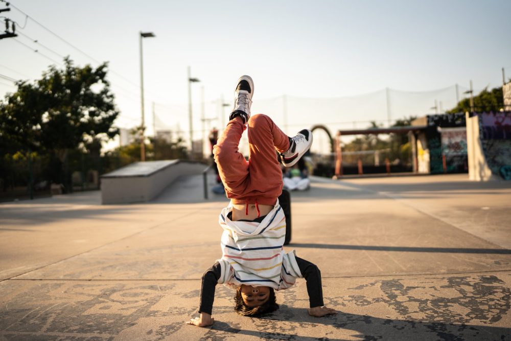Portrait of child boy breakdancing at skateboard park