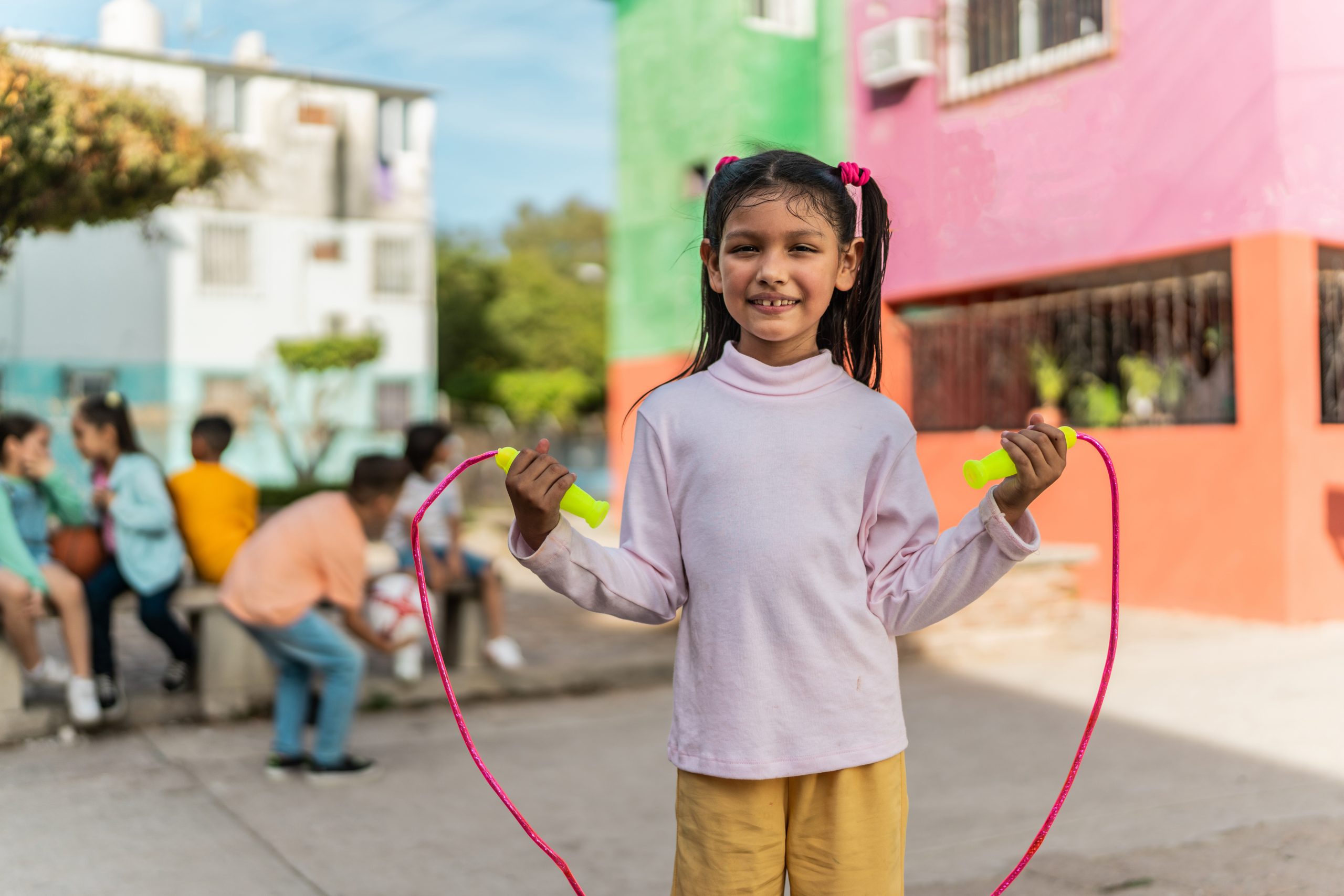 Portrait of child girl playing rope outdoors